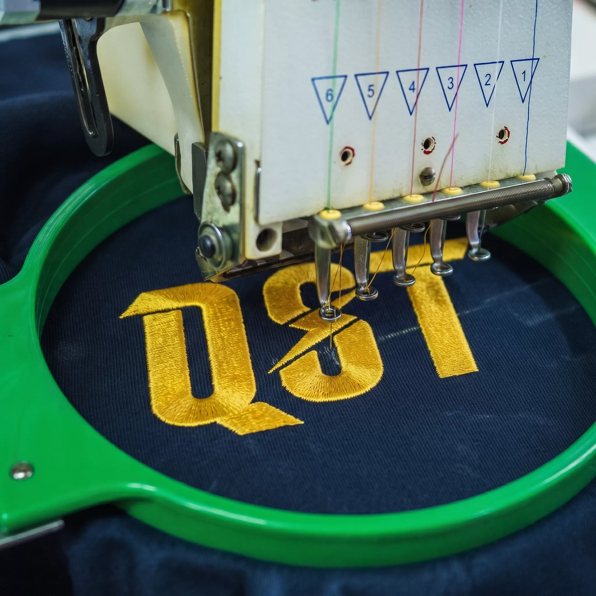 Embroidering a QST logo on a computerised embroidery machine