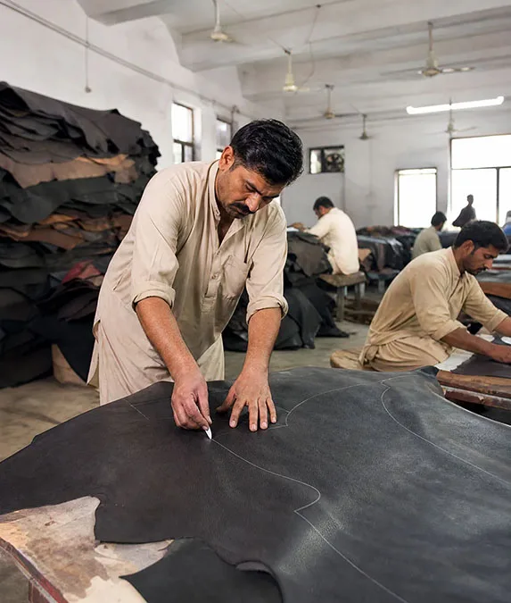 Leather cutting on the factory floor in Sialkot