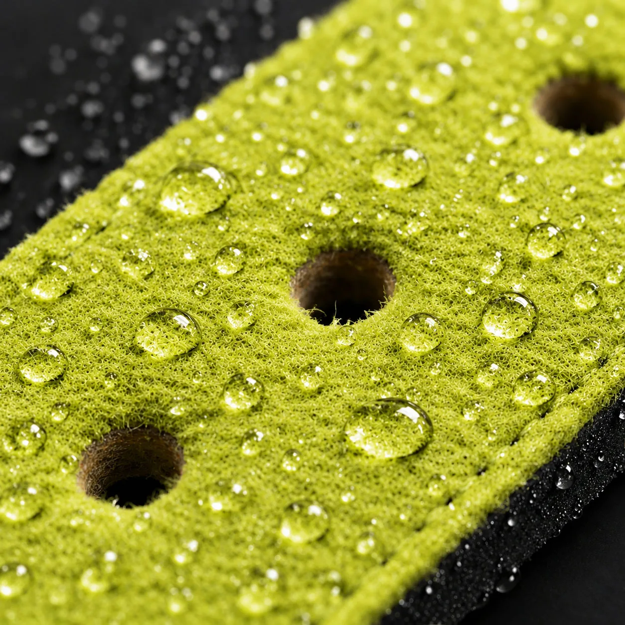 Close-up of lime felt belt lining with water beading on the surface
